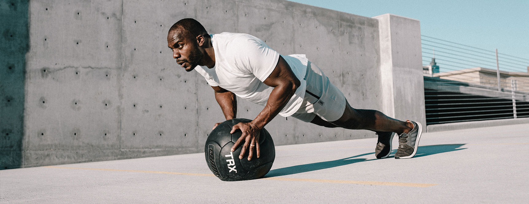 Man doing pushup with medicine ball to achieve peak performance